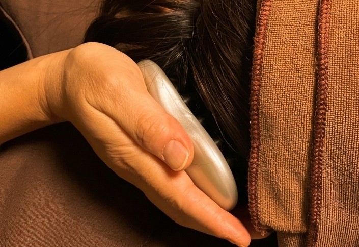 専用のかっさブラシで頭皮のコリをしっかり解きほぐす様子